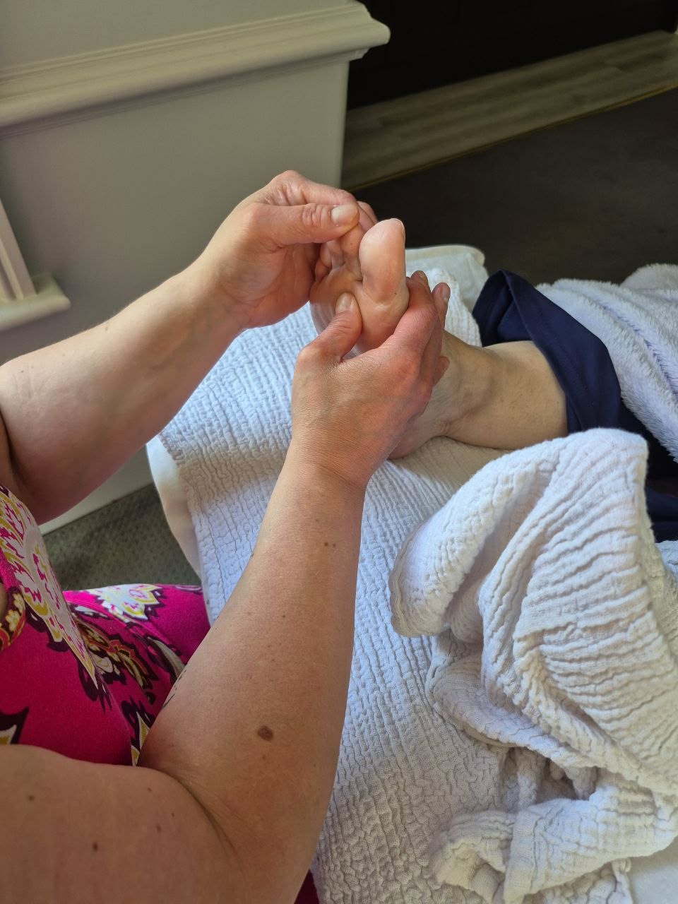 Charlotte applying gentle reflexology pressure to a client's foot